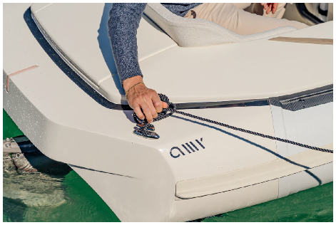 Hands securing a line to a deck cleat