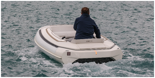 Operator at the helm of a tender on open water