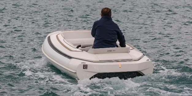 Operator at the helm of a tender on open water