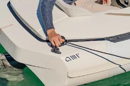 Hands securing a line to a deck cleat